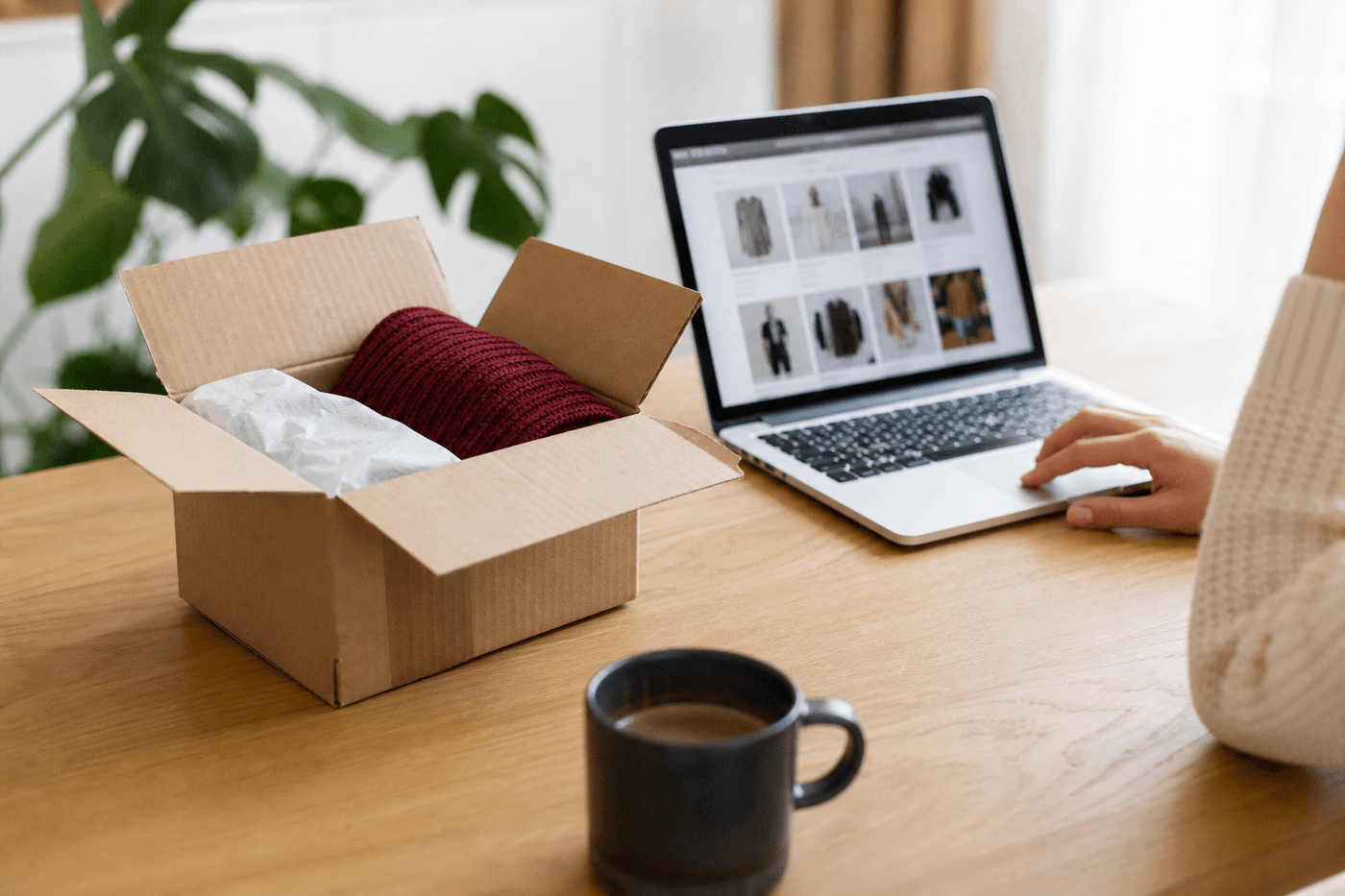 Un carton de colis ouvert sur une table avec un ordinateur portable affichant une page de commande en ligne